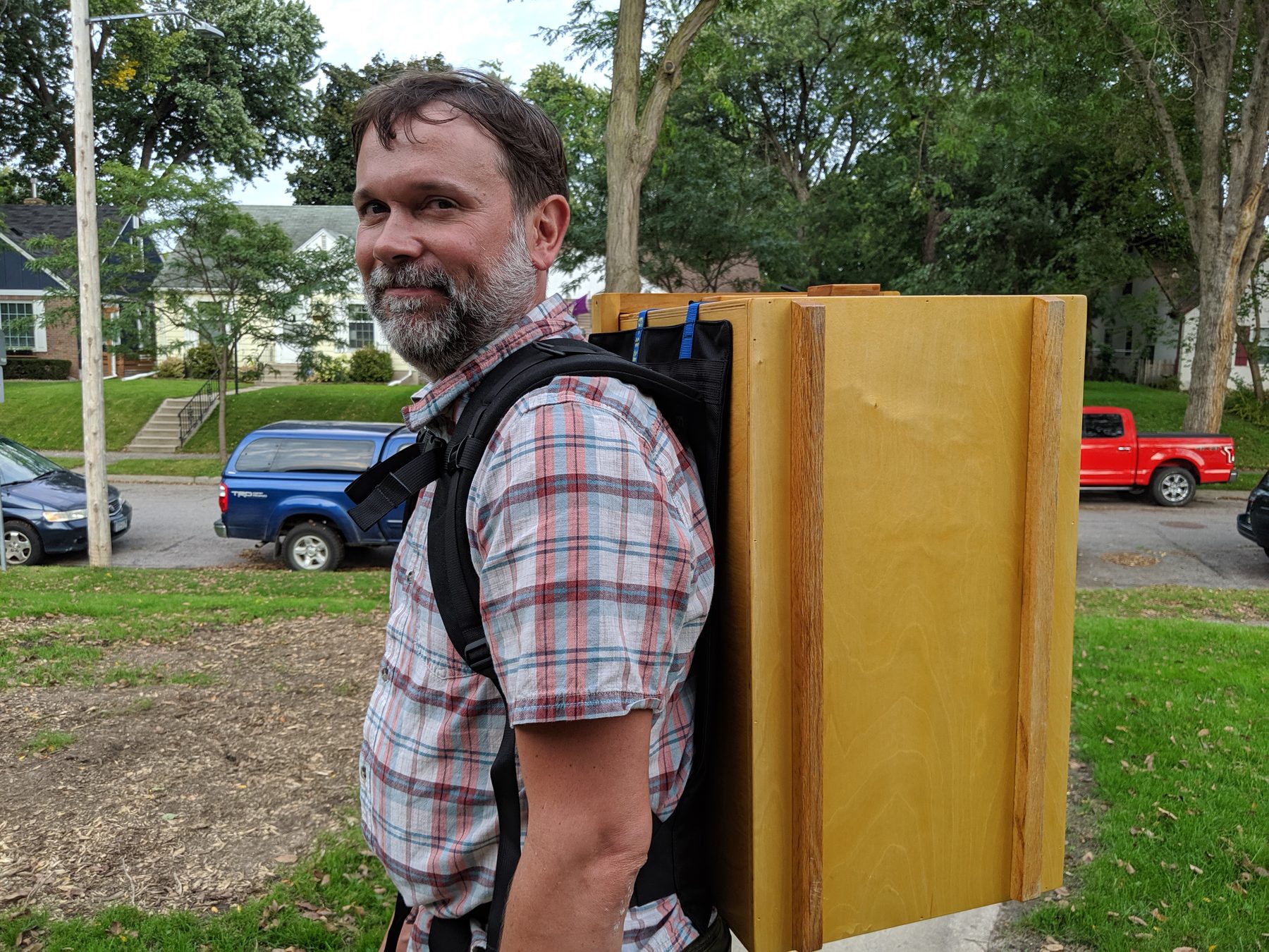 Wanigan worn as a backpack on a neighborhood sidewalk